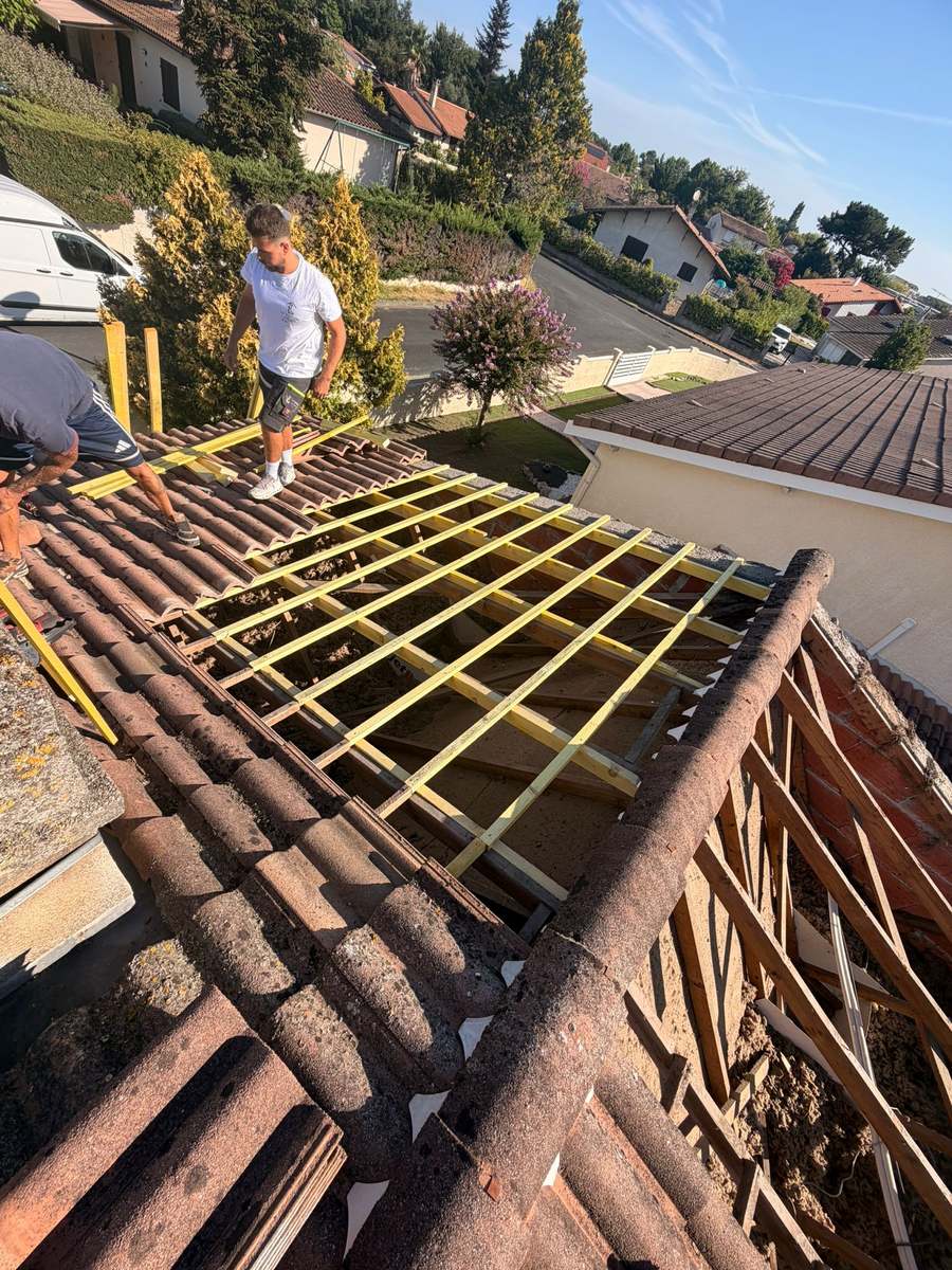 Rénovation de toiture à Salses-le-Château : couvreurs posant les liteaux neufs après dépose des tuiles